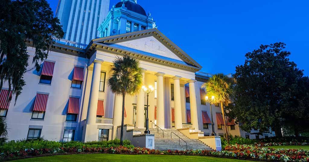 State capitol building at dusk, columned portico illuminated